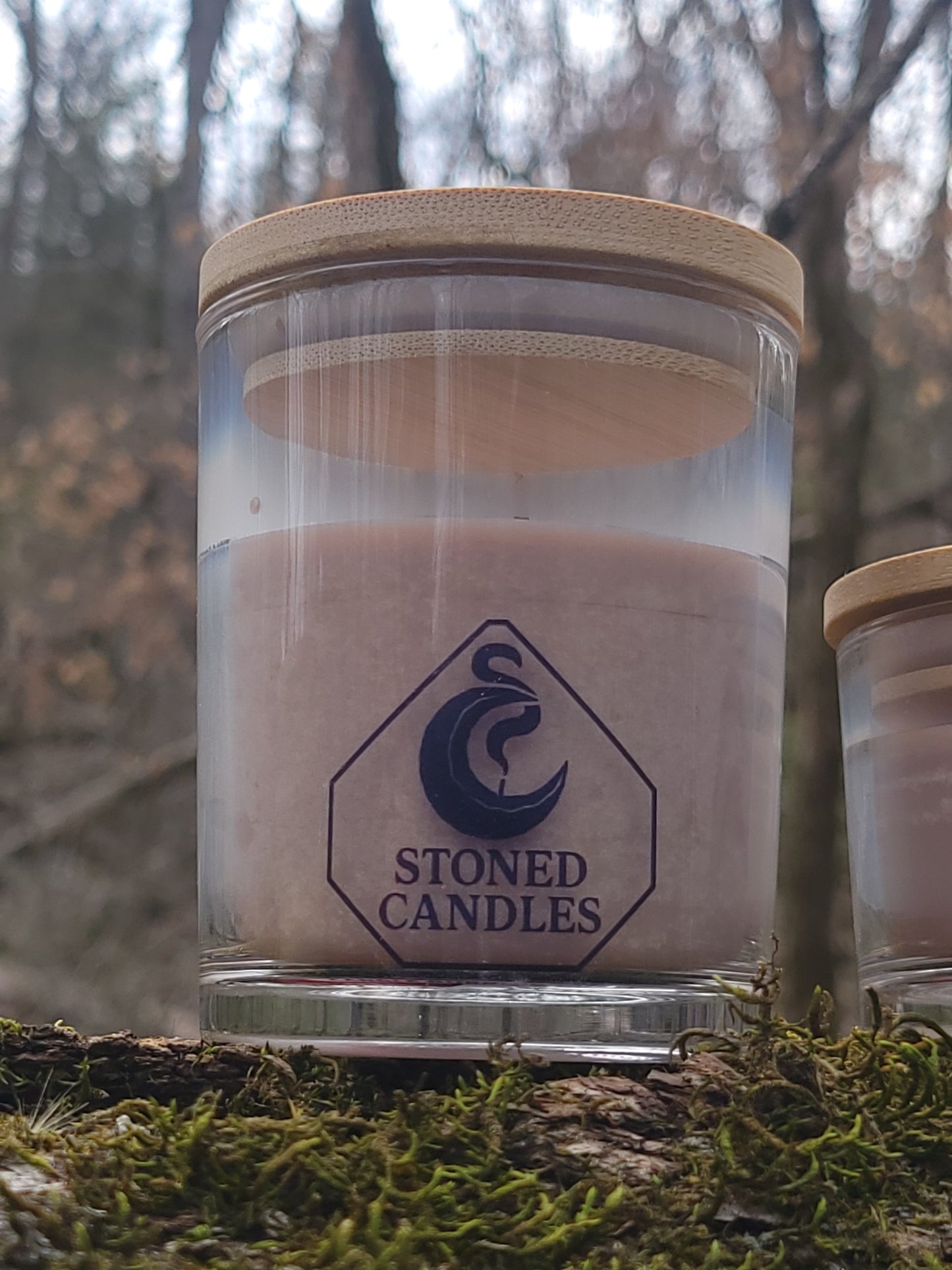 Glass candle jar with wooden lid on a natural background