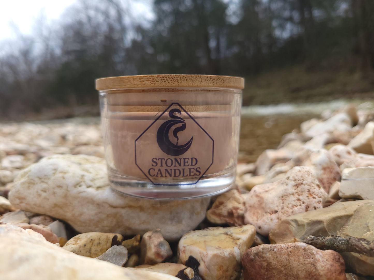 Jar of candles with a logo on a stone background