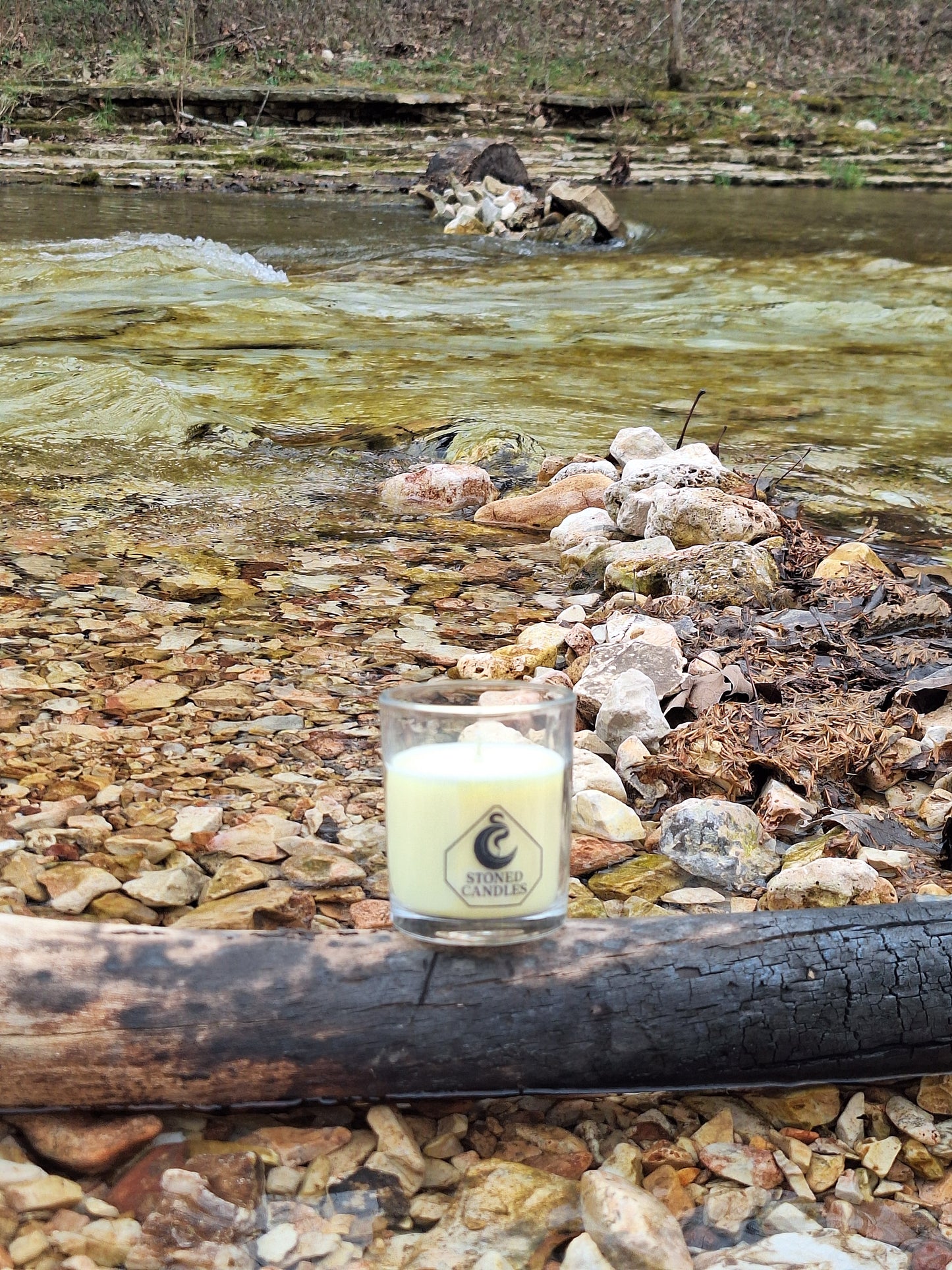 Small bottle with a label on a rocky and wooden surface